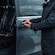 A man opening the door to a van with empty seats inside